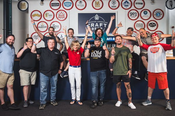 beer ambassadors posing in front of beer signs at london beer event