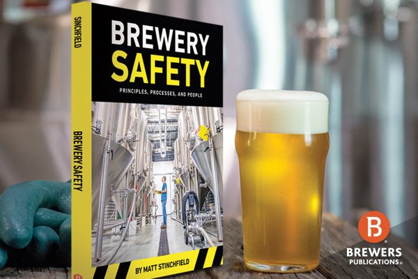 Brewery Safety Book next to a glass of beer and safety gloves