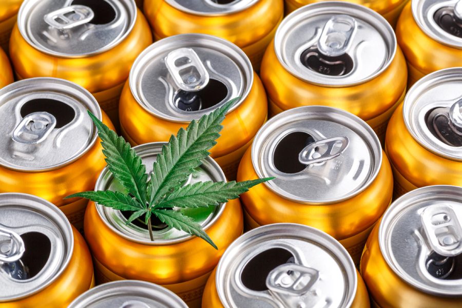 cans grouped together with a cannabis leaf laying on top