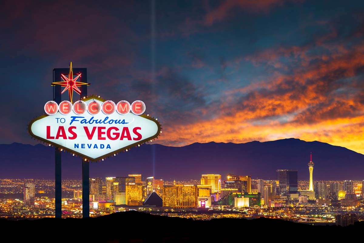 Las Vegas sign in front of skyline and outdoor scene at sunset