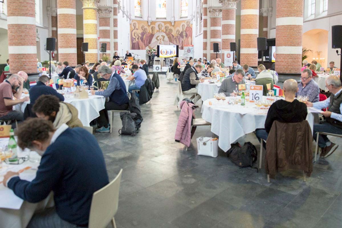 Beer judges seated at round tables judging beers in Brussels historic building