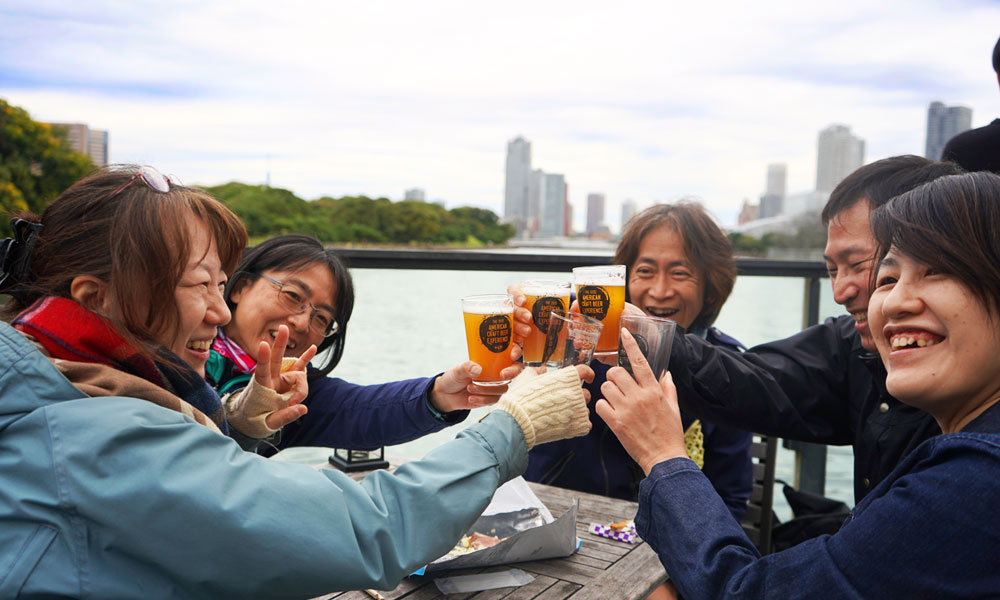 japanese beer enthusiasts cheersing in front of water