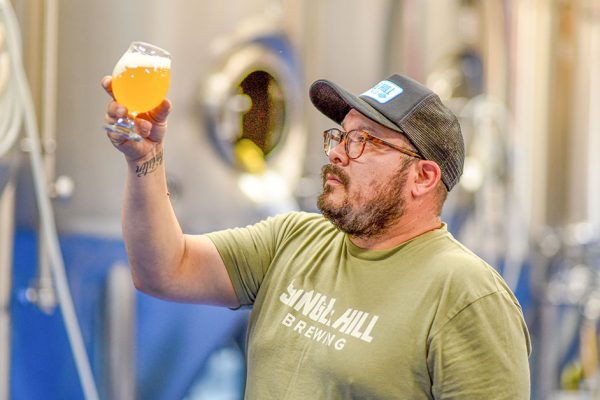 man contemplating beer in brewery x