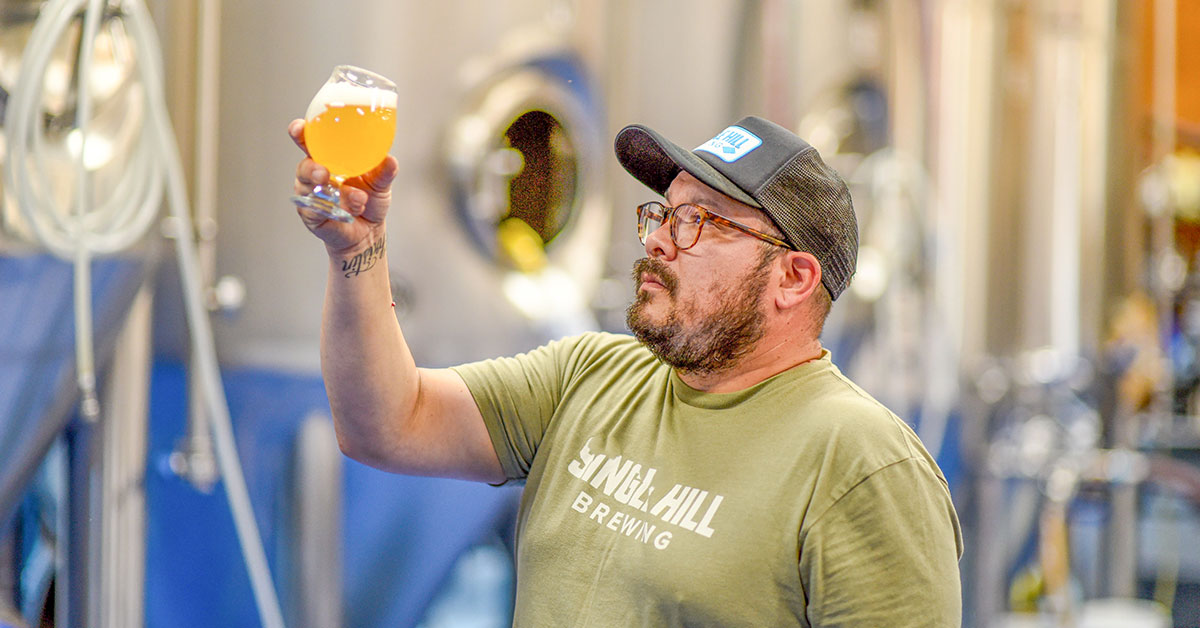 man contemplating beer in brewery x