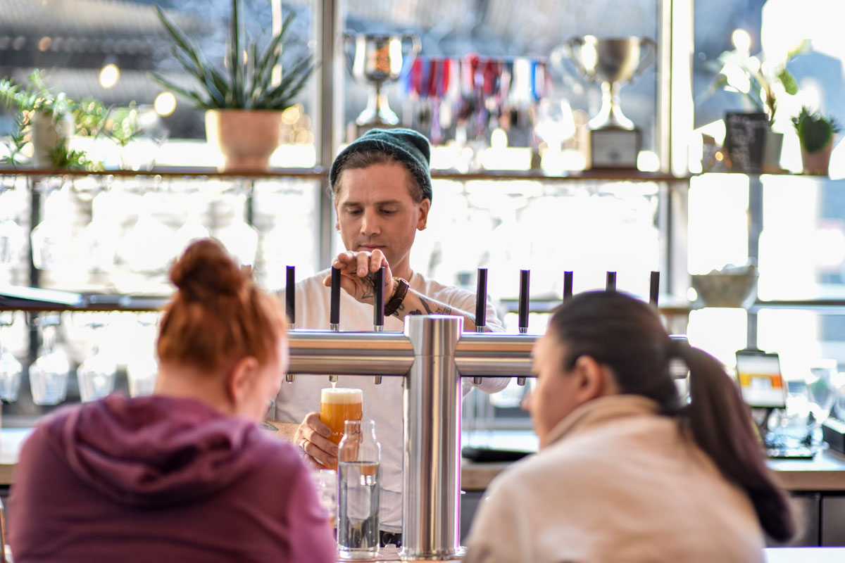 man pouring draught beer in brewery