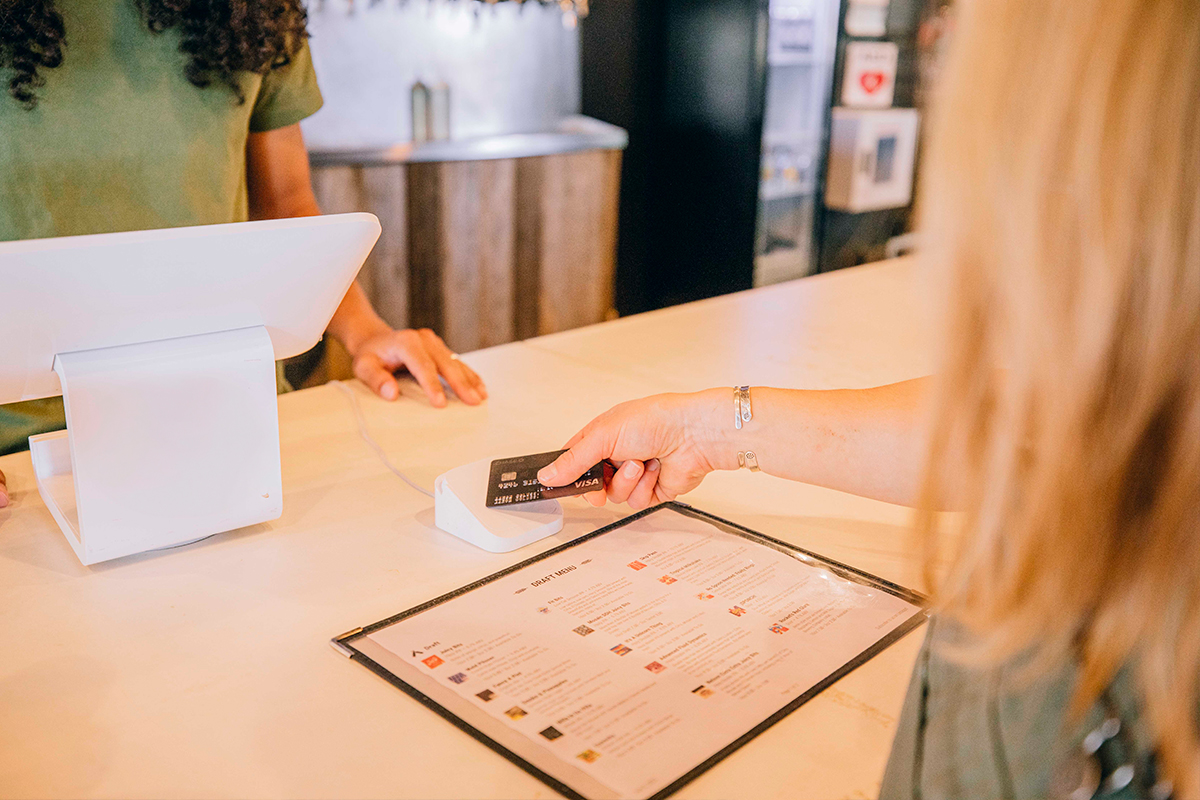 woman paying tab in brewer with credit card