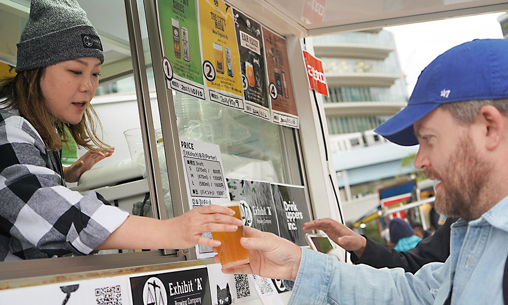 woman serving american craft beer out of beverage cart window